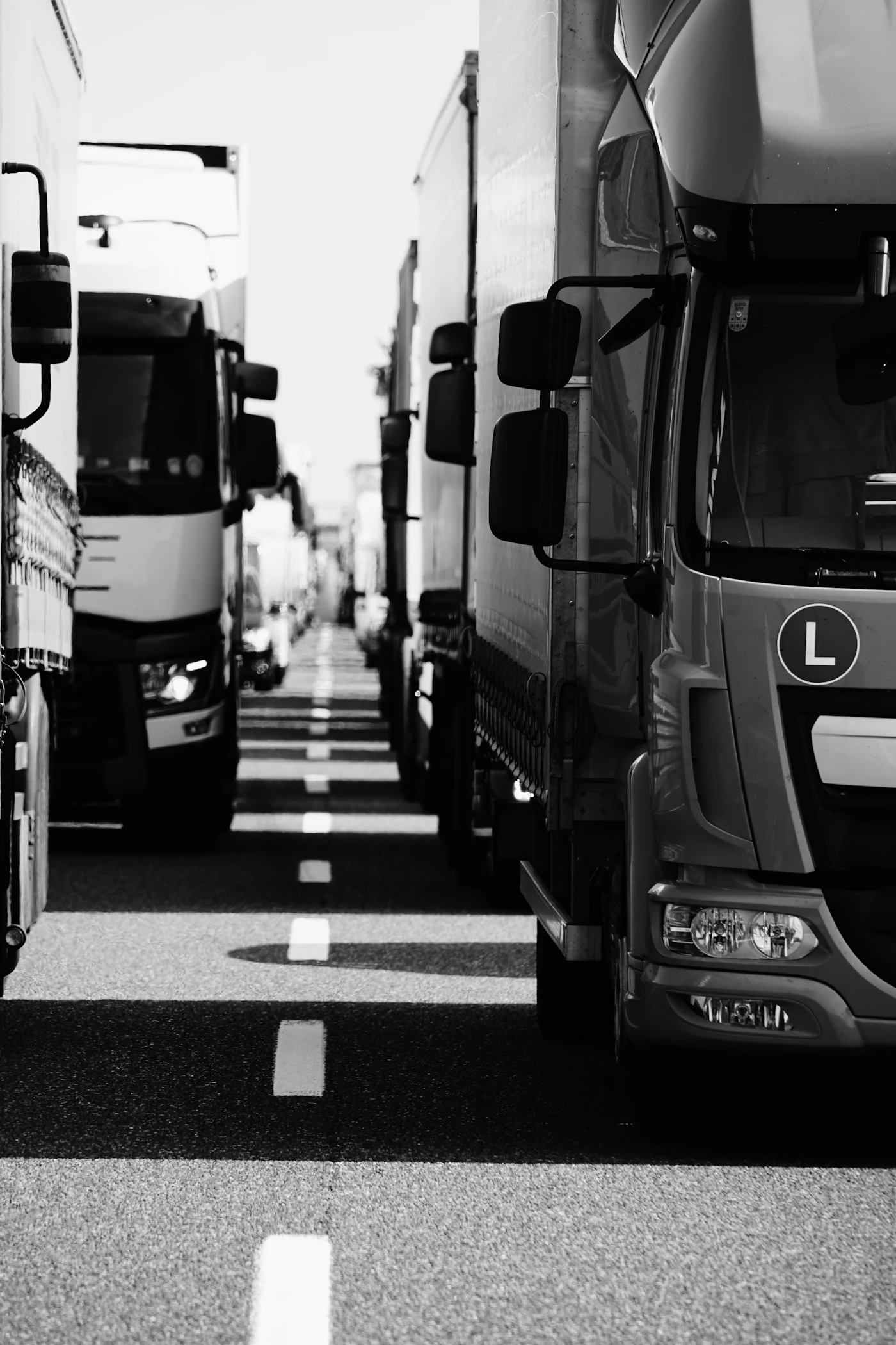 Camiões europeus estacionados em fila, a preto e branco